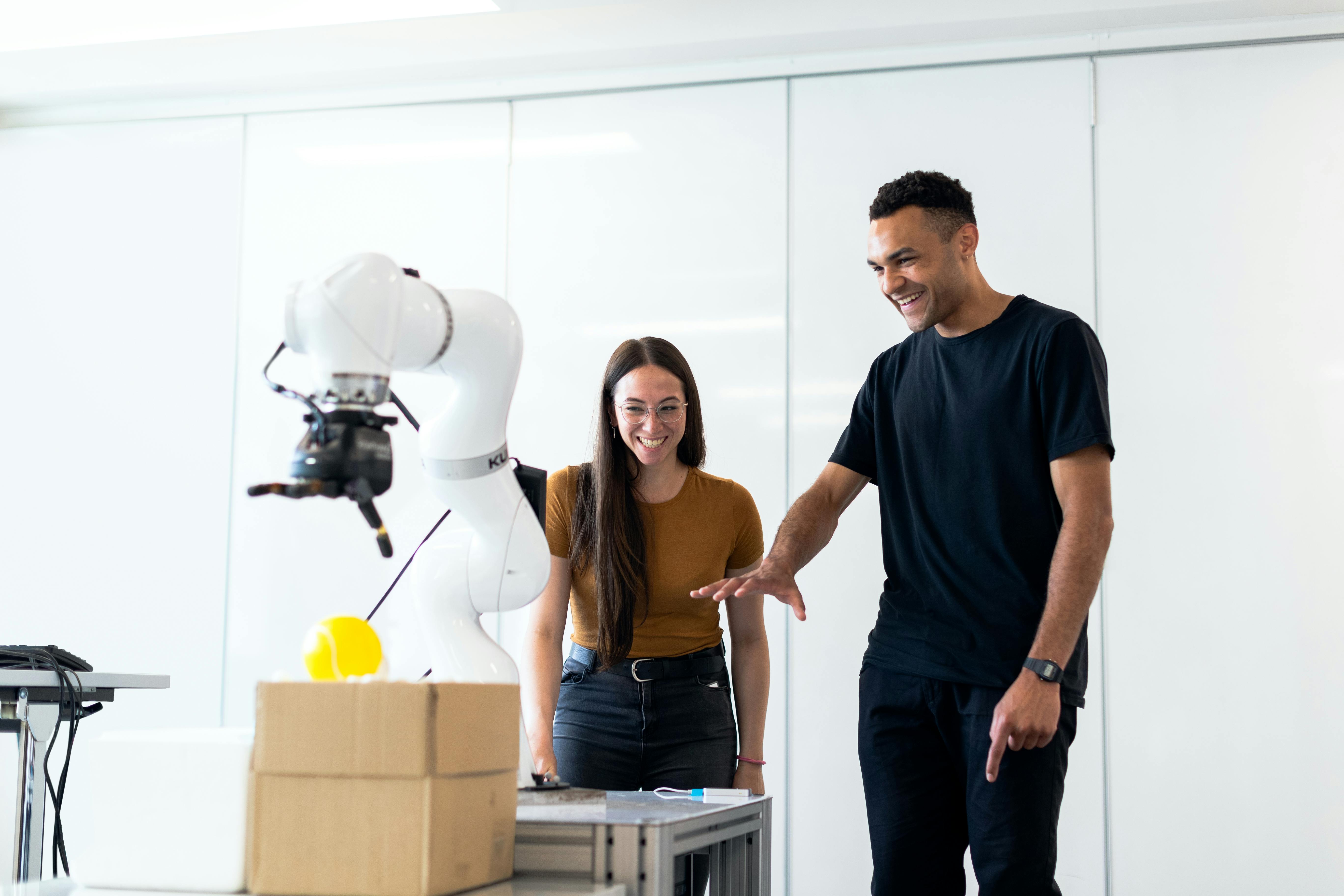 Engineers testing a robotic arm in a lab
